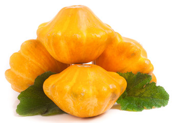 four yellow pattypan squash with leaf isolated on white background