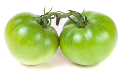 Two green unripe tomato isolated on white background