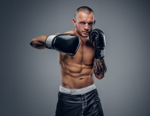 Shirtless fighter isolated on grey background.