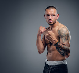 Shirtless fighter isolated on grey background.