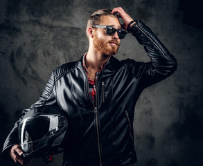 Redhead male holds motorcycle helmet.
