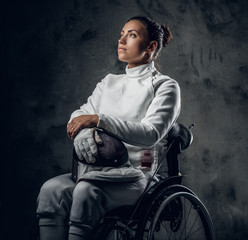 Female fencer in wheelchair with safety mask and rapier.