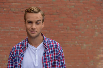 Handsome guy standing near brick wall