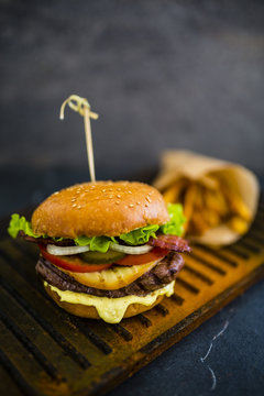 Tasty street food grilled beef burger in crispy shortbread with lettuce and mayonnaise served with french fries. Space for text.