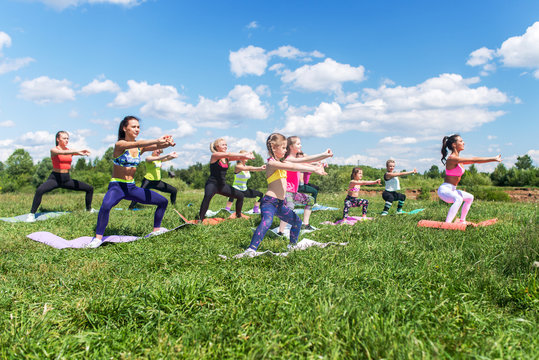 Group of women exercising and doing squats at boot camp.