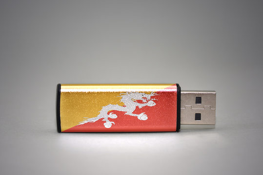 usb flash drive with the national flag of bhutan on gray background.
