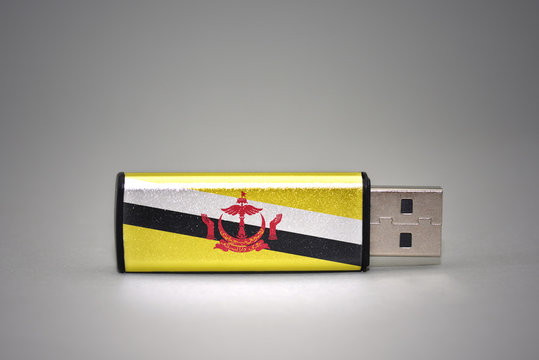 usb flash drive with the national flag of brunei on gray background.