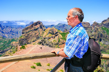 Naklejka premium Caucasian man viewing rocky mountains in landscape