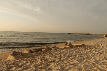 Piaskowa forteca na plaży o zachodzie słońca