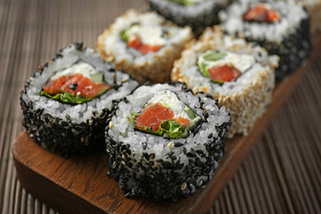 Delicious sushi rolls on table