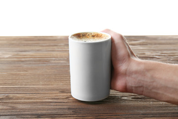 Man hand putting cup of coffee on wooden table