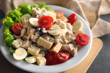 Plate with tasty salad on gray table
