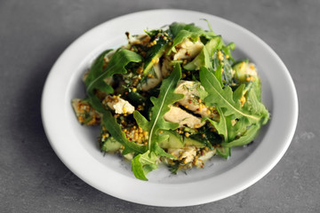 Tasty salad with chicken, cucumbers and arugula on plate