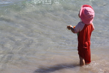 little girl with the red jumpsuit to the sea