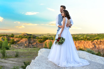 Bride and groom standing over beautiful landscape