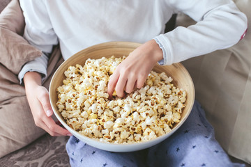 boy eating popcorn on a sofa in the dining room