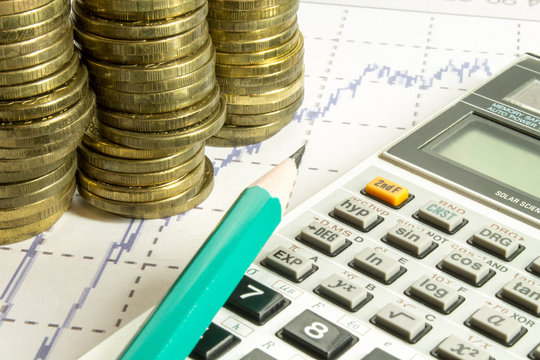 calculator,pencil and coins on graffica the Dow Jones