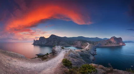 Foto op Plexiglas Prachtig panoramisch landschap met bergen, zee, blauwe lucht en prachtige kleurrijke rode wolken bij zonsondergang op de Krim. Zonsondergang in bergen. Pad in rots. Natuur achtergrond. Levendig landschap in de schemering. © den-belitsky