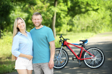 Obraz premium Happy couple with bicycles in the park
