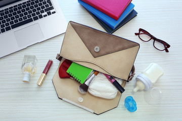 Mothers bag with accessories on table