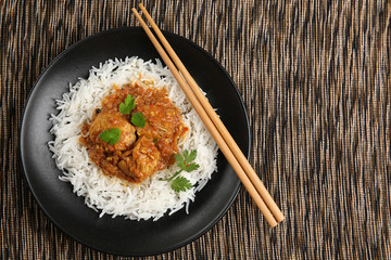 Tasty dinner with chicken curry and rice on plate, closeup