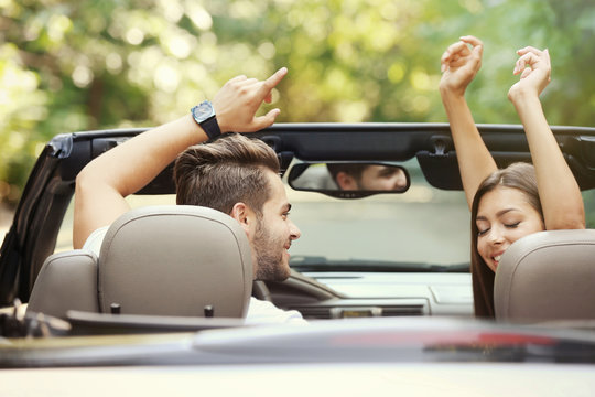 Beautiful couple listening music in car on road trip