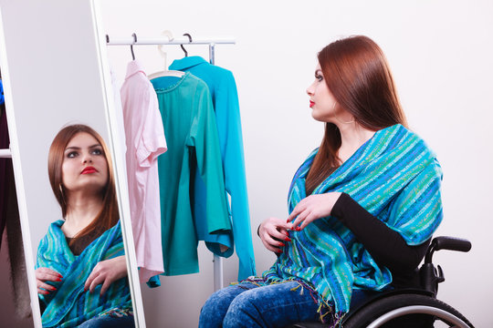 handicapped girl on wheelchair choosing clothes