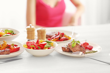 Tasty steak with fried vegetables on dinner table