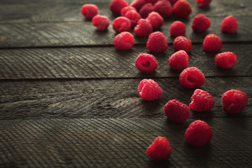 Scattered fresh raspberries on wooden background