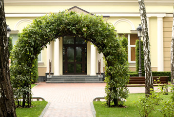 Green arch made of plants against modern building