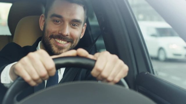 Happy Smiling Businessman Driving a Car. Shot on RED Cinema Camera.