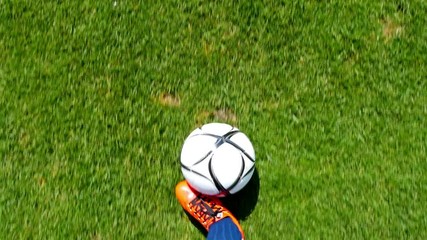 Footballer leading the ball on a football field, top view