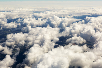 Aerial view of thick clouds over the land, the landscape. The texture of the scenic sky illuminated by the rays of the sun. 