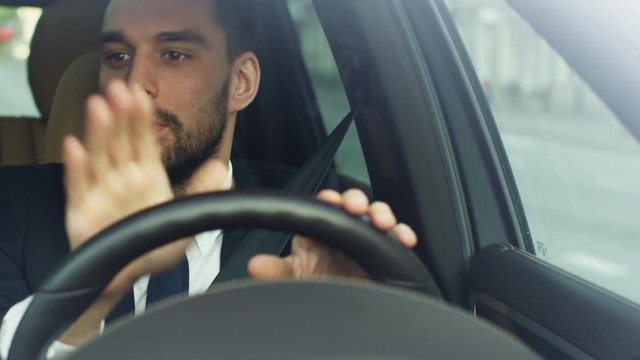 Excited Businessman Listening to Music While Driving a Car. Shot on RED Cinema Camera in 4K (UHD).