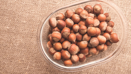 Hazelnuts in shell in transparent glass dish