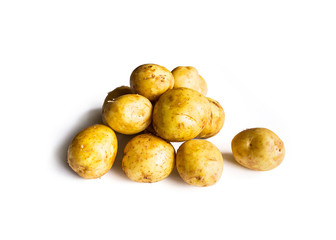beautiful pile of small rounded whole organic potatoes with the peel isolated on a white background with focal blur