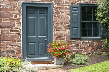 Fototapeta na wymiar Countryside house stone wall facade with door and window