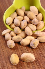 Pistachio nuts in bowl on wooden table, healthy eating
