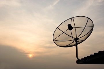 black antenna communication satellite dish over sunset sky