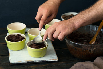 Man preparing chocolate dessert on dark wooden table