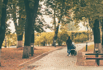 Young mother walks in the city park