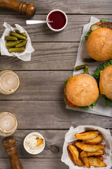 Different burgers and cheeseburger with sauces, fries, pickles a