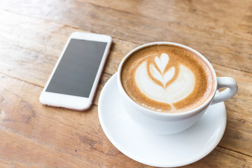 Coffee cup and mobile phone on wood table background, fillter ef