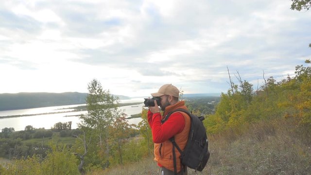 hiking man with a backpack photographed on a photo camera natural autumn landscape