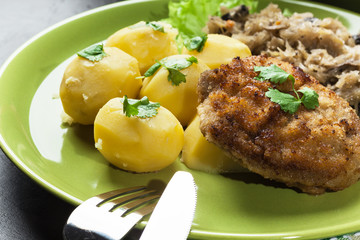 Fried pork schnitzel served with boiled potatoes and fried sauer
