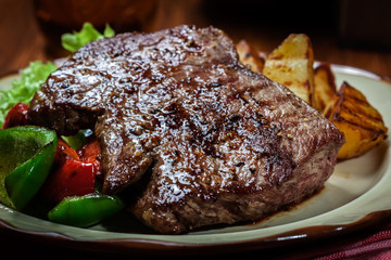 Portions of grilled beef steak with grilled potatoes and paprika