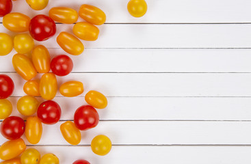 Naklejka na ściany i meble Colorful cherry tomatoes on white table background, top view.
