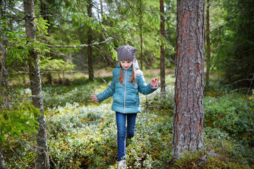 Cute funny little girl having fun during hike in a woods