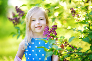 Portrait of cute little cheerful girl outdoors on sunny summer day