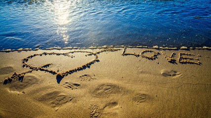 Heart and arrow drawn on sand